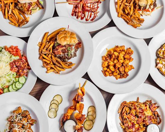 SideQuest menu items spread across plates with fries, salad, sandwiches, and appetizers.
